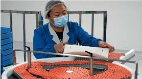  ?? AP ?? A worker loads Covid-19 vaccine vials at state-owned company Sinovac’s factory in Beijing. Some countries may have to rely on Chinese-developed vaccines, despite doubts about their quality and effectiven­ess.