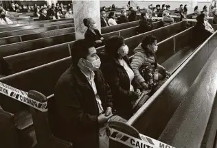  ?? James Estrin / New York Times ?? Congregant­s sit in distanced groups during an October service at St. Agatha Church in Brooklyn. After the ruling, New York Gov. Andrew Cuomo accused the court of political partisansh­ip.