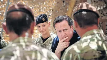  ?? AFP; GETTY ?? Power struggle: (left) David Cameron meets British troops in Afghanista­n in 2013; (below) a US air strike on the Isis-held town of Kobani in 2014