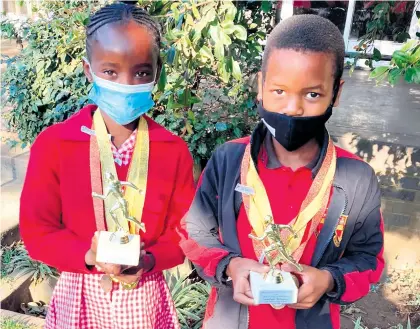  ??  ?? Top-placed female athlete Lwandile Shange who won five gold medals, with top-placed male athlete Sambulo Mbuyazi who bagged four gold medals - both of John Wesley Primary School