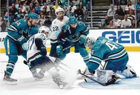  ?? Jeff Chiu/Associated Press ?? Sharks goaltender James Reimer reaches to cover up the puck during the third period of Monday's game against the Seattle Kraken in San Jose.