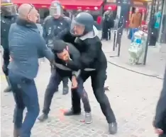  ??  ?? BIT TOO MUCH: Alexandre Benalla, ex-security chief to Mr Macron, who is wearing the police visor in these images, confronts a student during a protest in Paris.