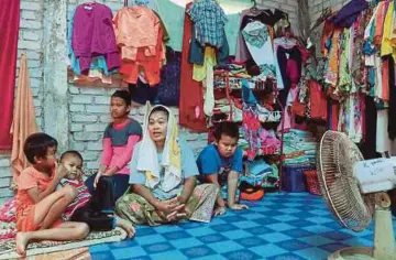  ??  ?? UMI Ros Ellyinda bersama empat anaknya di dalam rumah mereka di Kampung Tiong, Kota Bharu.