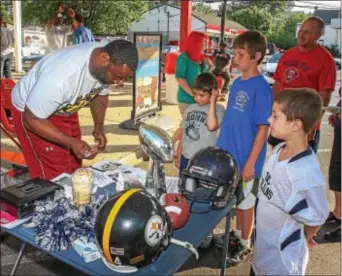  ??  ?? Former Pittsburgh Steeler and Pottstown alum Rian “Goo” Wallace signs autographs young children outside Rita’s Water Ice in support of the PAL football program. for