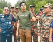  ?? BERNAMAPIX ?? Syed Saddiq being given updates by Negri Sembilan Fire and Rescue Department chief Norazam Khamis (left) on the search operation for Yuen.