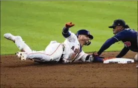  ?? SUE OGROCKI / ASSOCIATED PRESS ?? Atlanta second baseman Ozzie Albies tags out Houston’s Yuli Gurriel at second during Game 1 of the World Series in Houston on Tuesday night. Boosted by a strong bullpen effort, a two-run homer by Adam Duvall and a late sacrifice fly from Freddie Freeman, the Braves coasted 6-2 in their first Series appearance since Chipper Jones and their Big Three aces ascended in 1999 only to lose to the Yankees.