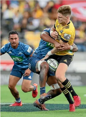  ?? PHOTOSPORT ?? Hurricanes fullback Jordie Barrett is wrapped up by the Blues.