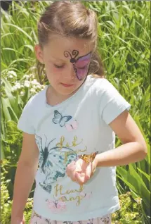  ??  ?? LEFT: Jack Ronacher, 8, regards the Painted Lady butterfly resting on his hand after it was released. Ronacher was at the Butterfly Effect fundraiser to honour his Grandpa Mike. RIGHT: Seven-year-old Harper Sivucha’s butterfly stayed with the girl long...