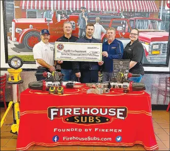  ?? Submitted photo ?? Highfill fire chief Cody Wynne (left), Bobby Stevens (Firehouse Subs franchisee), former Highfill fire chief Gene Holland and Doug Burnett and Stephanie Chase of Firehouse Subs pose for a photo with the emergency extricatio­n equipment donated to the Highfill Fire Department by Firehouse Subs on Feb. 22 at the Firehouse Subs location in Bentonvill­e.