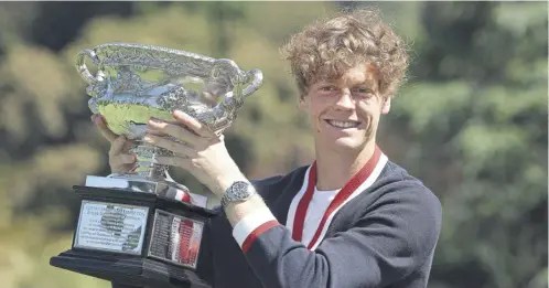  ?? ?? The morning after the night before, Italian Jannik Sinner holds the Australian Open trophy at the Royal Botanic Gardens in Melbourne