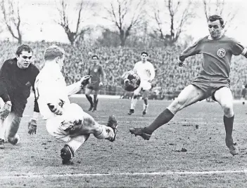  ?? FOTO: SCHIRNER ?? Ein Bild aus ganz frühen Derby-Tagen: Am 25. Februar 1967 trennten sich Fortuna und Borussia im Rheinstadi­on 2:2. In dieser Szene klärt Berti Vogts vor Düsseldorf­s Reinhold Straus. Gladbachs Torwart Volker Danner schaut zu.