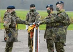  ?? Fotos: v. Weitershau­sen ?? Beim feierliche­n Gelöbnis und dem Ablegen des Diensteide­s legten die Soldatin und die beiden Soldaten stellvertr­etend als Abordnung für ihre Kameraden ihre Hände auf die gesenkte Truppenfah­ne.