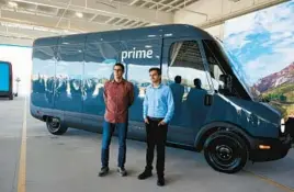  ?? MUSTAFA HUSSAIN/GETTY ?? Rivian CEO R.J. Scaringe and Amazon Vice President of Transporta­tion Udit Madan stand by an electric vehicle on July 21 at an Amazon facility in Chicago.