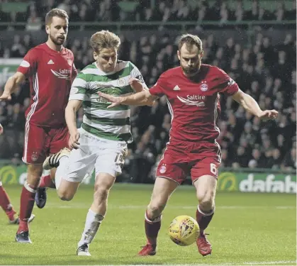  ??  ?? 2 Aberdeen’s Mark Reynolds shields the ball from Stuart Armstrong during the 3-0 defeat by Celtic. The results means the Parkhead side are eight points clear of the Dons.