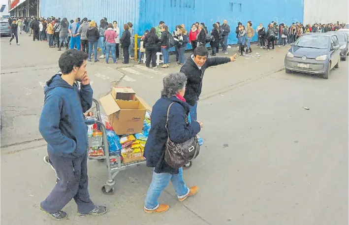  ?? MAURICIO NIEVAS ?? Una espera interminab­le. Durante todo el día hubo largas filas de clientes para ingresar a los hipermerca­dos de La Plata. Algunos locales debieron extender sus horarios.