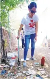  ?? ADOLPHE PIERRE-LOUIS/JOURNAL ?? Jessica Jaramillo, of the county Department of Behavioral Health, uses a grabber to pick up syringes near two abandoned duplexes on Chico NE.