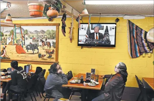  ?? JOE RAEDLE/GETTY ?? Diners at El Toro Bronco restaurant in El Paso, Texas, watch President Donald Trump’s televised Jan. 19 speech about the need for a wall on the U.S.-Mexico border.