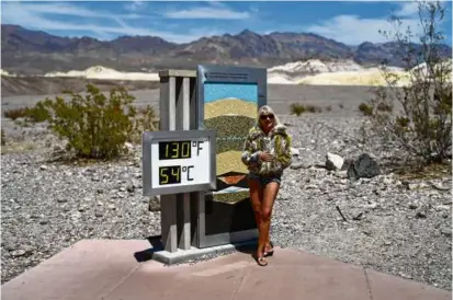  ?? JOHN LOCHER/ASSOCIATED PRESS/FILE ?? A woman posed by a thermomete­r in Death Valley National Park, Calif., last week. In the past 30 days, nearly 5,000 heat and rainfall records have been broken or tied in the United States.