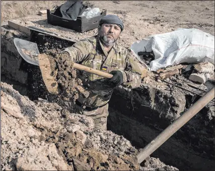  ?? Vadim Ghirda The Associated Press ?? A Ukrainian serviceman in March digs a trench at a position north of the capital, Kyiv.