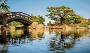  ??  ?? A Japanese moon bridge arches under a bright summer sky.