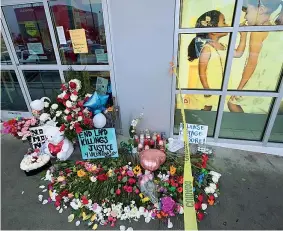  ?? (Robyn Beck / AFP) ?? L’omaggio Fiori, candele e biglietti davanti alla Burlington Coat Factory