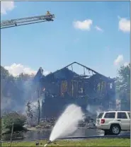  ?? MARIAN DENNIS — DIGITAL FIRST MEDIA ?? Crews utilize ladders and hoses on the ground to kill remaining hot spots.