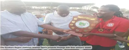  ?? ?? Zifa Southern Region chairman Andrew Tapela presents Hwange with their winners’ shield