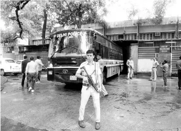  ?? — AFP photo ?? Indian police escort a police bus carrying arrested All Parties Hurriyat Conference (APHC) leaders at Patiala House Court in New Delhi.