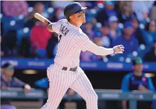  ?? DAVID ZALUBOWSKI/ASSOCIATED PRESS ?? Colorado Rockies pinch-hitter Yonathan Daza follows the flight of his double that drove in three runs off Miami Marlins relief pitcher Cole Sulser in the seventh inning Monday in Denver.