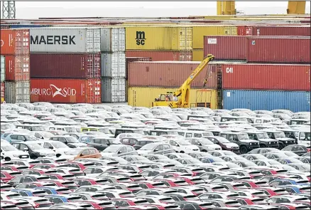  ??  ?? In this file photo, cars for export and import are stored in front of containers at the port in Bremerhave­n, Germany. In June 2019 German industrial production dropped significan­tly for the second time in three months. (AP)