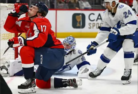  ?? John McDonnell/Associated Press ?? Washington’s Dylan Strome, left, reacts to getting hit on the face, while Tampa Bay defenseman Matt Dumba, right, clears the puck from in front of the Lightning goal.