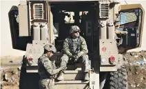  ??  ?? US ARMY soldiers sit next a military vehicle in the town of Bartella, east of Mosul, Iraq, Dec. 27, 2016.