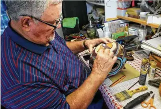  ?? Marvin Pfeiffer / Staff photograph­er ?? Converse resident David Cleaveland puts the final touches on a dried gourd with inlaid turquoise and aluminum shavings adorned with bear claws in his workshop garage.