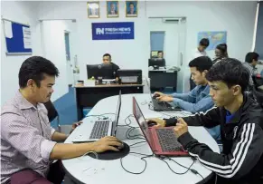  ?? — AFP ?? Chasing after leads: Fresh News staff members working in their newsroom in Phnom Penh.