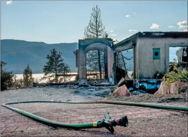  ?? MARISSA BAECKER/Special to The Daily Courier ?? The charred remains of a home on Nighthawk Road stand in the aftermath of the Okanagan Centre fire on Sunday evening in Lake Country. Eight homes were engulfed as the fire grew to 55 hectares in size.