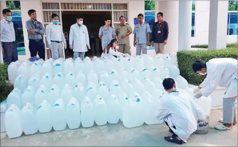  ?? COMMERCE MINISTRY ?? Officials inspect fake hand sanitisers seized in Phnom Penh last year.