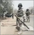  ??  ?? Nigerian soldiers man a checkpoint in a liberated town