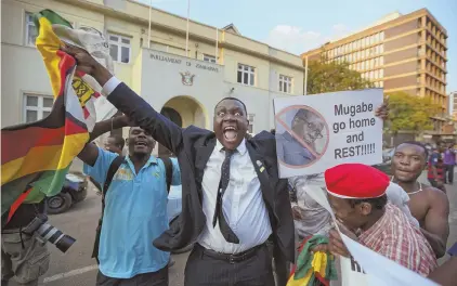  ?? AP PHOTOS ?? ELATION: Zimbabwean­s celebrate outside the parliament building immediatel­y after hearing the news that President Robert Mugabe, top, had resigned, in downtown Harare, Zimbabwe yesterday.