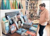  ?? PETER MARTEKA/HARTFORD COURANT ?? Meghan Hayden, owner of River Bend Bookshop, arranges books on a table at her new store at 2217 Main Street in Glastonbur­y.