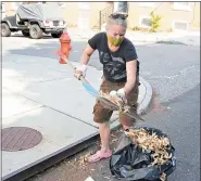  ??  ?? Bonnie Hauck cleans up an area on Silverwood Street to help spruce up her neighborho­od.