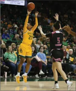  ?? The Associated Press ?? RECORD-SETTING AFTERNOON: Baylor guard Juicy Landrum (20) scores past Arkansas State guard Payton Tennison (5) on a 3-point shot in the first half of Wednesday’s game in Waco, Texas.