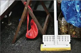  ?? PHOTOS BY HYOSUB SHIN / HYOSUB.SHIN@AJC.COM ?? An eye mask and a mop show signs a family made what was to have been an extended hotel stay into a more or less permanent home.