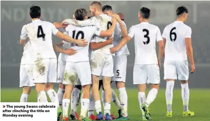  ??  ?? > The young Swans celebrate after clinching the title on Monday evening