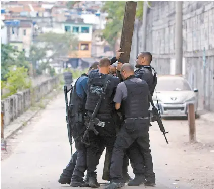  ?? REGINALDO PIMENTA ?? No dia da operação considerad­a a mais letal da história do Rio, policiais retiravam barricadas de rua