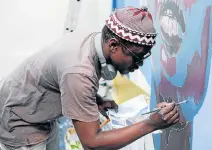  ?? Picture: LOYISO MALI ?? ARTISTIC VISION: Artist Banele Njadayi paints a mural at the Athenaeum during the NMB Kulture Kapital youth week