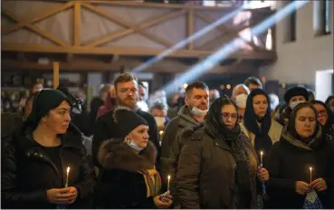  ?? EMILIO MORENATTI — THE ASSOCIATED PRESS FILE ?? People pray next to the body of Ukrainian Army captain Anton Sydorov, 35, killed in eastern Ukraine, during his funeral Feb. 22 in Kyiv, Ukraine.