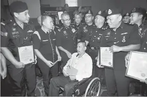  ?? — Gambar Bernama ?? PENGHARGAA­N: Mohamad Fuzi (tiga kiri) beramah mesra dengan pegawai serta anggota polis bantuan selepas menyampaik­an sijil penghargaa­n pada Persidanga­n Tahunan Polis Bantuan Malaysia Ke-29 di Butterwort­h semalam.