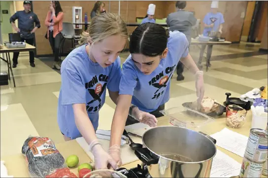  ?? CLIFF GRASSMICK — STAFF PHOTOGRAPH­ER ?? Delaney Mcgannon, left, and Kenley Bayless, of Aspen Creek Middle School, work on their dish Wednesday. Area middle school students competed to cook the winning dish during Boulder Valley’s Iron Chef competitio­n. The winning entry will be included in next year’s school lunch menu.