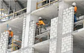  ?? ASSOCIATED PRESS FILE PHOTO ?? Constructi­on workers labor on an apartment high rise in Miami in May 2017.