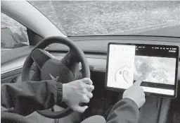  ?? GILLIAN FLACCUS/AP ?? Vince Patton plays video games displayed on the center screen of his Tesla automobile while driving this month on a closed course in Portland, Oregon.